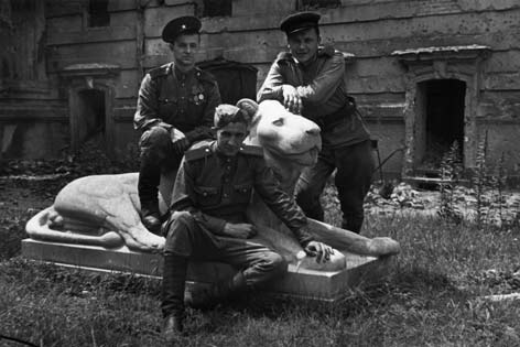 Three Red Army soldiers pose with the Mosse lion.