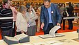 A man presents a musical manuscript to visitors