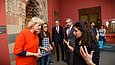 Eine junge Frau erklärt einer Besuchergruppe etwas