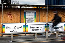 Laubengang einer Baustelle mit Plakaten mit Regenbogenmotiven