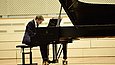 Ein Mann spielt auf einer Bühne Klavier