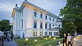 Festlich illuminierte neoklassizistische Villa in der Abenddämmerung