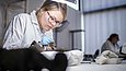 Zwei Restauratorinnen arbeiten konzentriert an kleinen Holzobjekten
