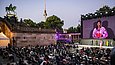 Gut gefülltes Open-Air-Kino mit historischer Architekturkulisse