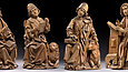 Vier sitzende Figuren, aus Holz geschnitzt