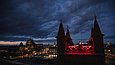 Ein Turm der Friedrichswerderschen Kirche vor dem wolkenverhangenen Nachthimmel. 