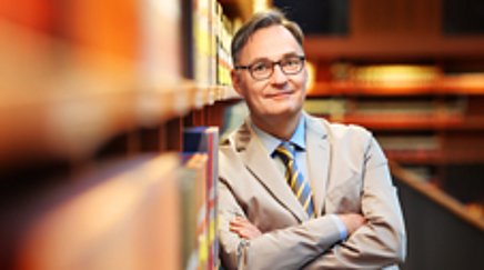 Portrait of a man in a library.