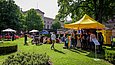 Menschen in einem Parkgelände mit einem gelben Pavillon