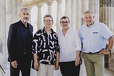 4 Personen stehen vor historischen Säulen