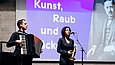 Ein Mann mit Akkordon und eine Frau singend am Mikrofon auf einer Bühne