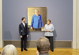 Angela Merkel and Jérémie Queyras are standing in front of the portrait of the former Chancellor.