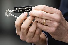 Hände halten einen Schlüssel mit der Aufschrift "Neue Nationalgalerie 29.4.2021"