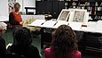 Frau präsentiert Objekte in einer Bibliothek