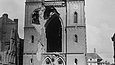 schwarz-weiß-Foto einer bombenbeschädigten Kirche mit klaffendem Loch in der frontalen Backsteinwand