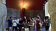 Besuchergruppe steht mit einem Museumsguide vor steinernen Kolossalfiguren im Museum