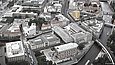 Luftbild eines Stadtraums mit Prachtbauten, in das die computergenerierte Visualisierung eines modernen Ausstellungshauses eingefügt ist