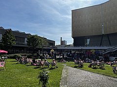 Tag im Grünen - Staatsbibliothek zu Berlin Menschen auf Liegestühlen im Philharmonischen Garten an einem sonnigen Tag