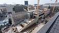 Betonlastiger Rohbau eines langgezogenen moderne Gebäudes mit Gerüst und zwei Kränen