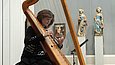 Frau spielt Harfe im Museum