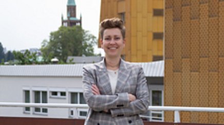 A woman in a suit poses for a picture