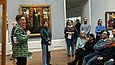 Frau spricht zu Besucher*innen im Museum
