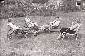 Schwarzweiß-Foto von Personen auf Stühlen im Gras