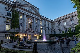 Außenansicht der Staatsbibliothek zu Berlin Unter den Linden mit dem beleuchteten Eingangsbereich des Stabi Kulturwerks.