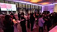 Menschen an Stehtischen in einem Foyer