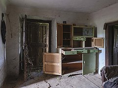 An abandoned kitchen with old furniture and items left behind in Topolje, Serbia.