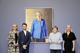 Vier Personen stehen vor dem Porträt der ehemaligen Bundeskanzlerin Angela Merkel im Bode-Museum.