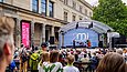 Publikum blickt auf eine Open-Air-Bühne