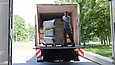Ein Mann lädt einen Bücherwagen von einem LKW ab