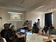 Workshop zur Erforschung der Nuba-Fotografien Prof. Shamsoun erklärt bei einem Workshop in Kampala einen Beerdigungsprozess
