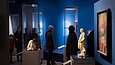 Mehrere Menschen sehen sich in einem Ausstellungsraum Exponate an