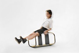 Xue Song: DYSTA, 2021 Eine verschwommene Frau sitzt auf einem quergestellten Stuhl