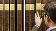 Man takes a file of drawings by Adolph Menzel from a shelf