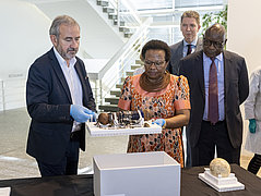 3 Männer und eine Frau stehen hinter einem Tisch mit einem namibischen Objekt