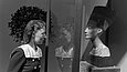 Eine Frau mit Haarnetz sieht sich die Büste einer Frau in einer Glasvitrine an