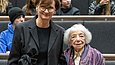 Eine mittelalte Frau und eine alte Frau stehen mit dem Rücken zum Publikum vor der Tribüne im Auditorium
