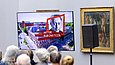 Auf einem Bildschirm wird vor Publikum etwas abgespielt