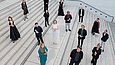 15 Personen stehen verstreut auf einer großen Freitreppe