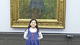 Girl in a blue dress in front of a painting of a girl in a blue dress