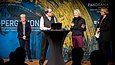 Drei Frauen stehen auf der Bühne, dazwischen ein zuhörender Mann