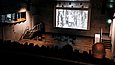 Filmprojektion vor Zuschauern in einem abgedunkelten Auditorium