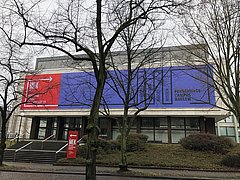 Gebäudeansicht der Museen Dahlem mit dem Banner des Forschungscampus Dahlem