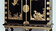 Black cabinet with gold decoration on six legs
