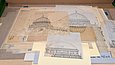 Verschiedene Papiere mit Architekturzeichnungen liegen auf einem Tisch