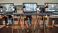 Ausstellungsbesucher betrachten Videos auf Monitoren