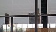Close-up of the glass facade with heavy damage from broken glass