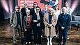 10 Personen stehen aufgereiht neben- und hintereinander